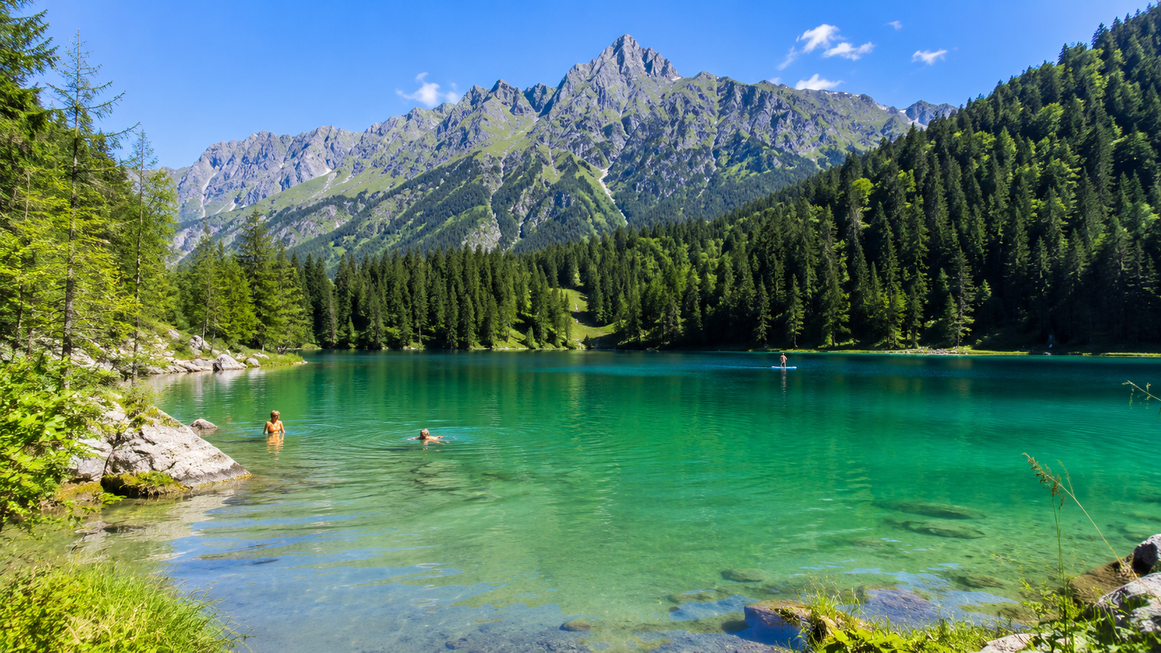 Kristallklarer Badesee in den bayerischen Alpen in Süddeutschland im Sommer